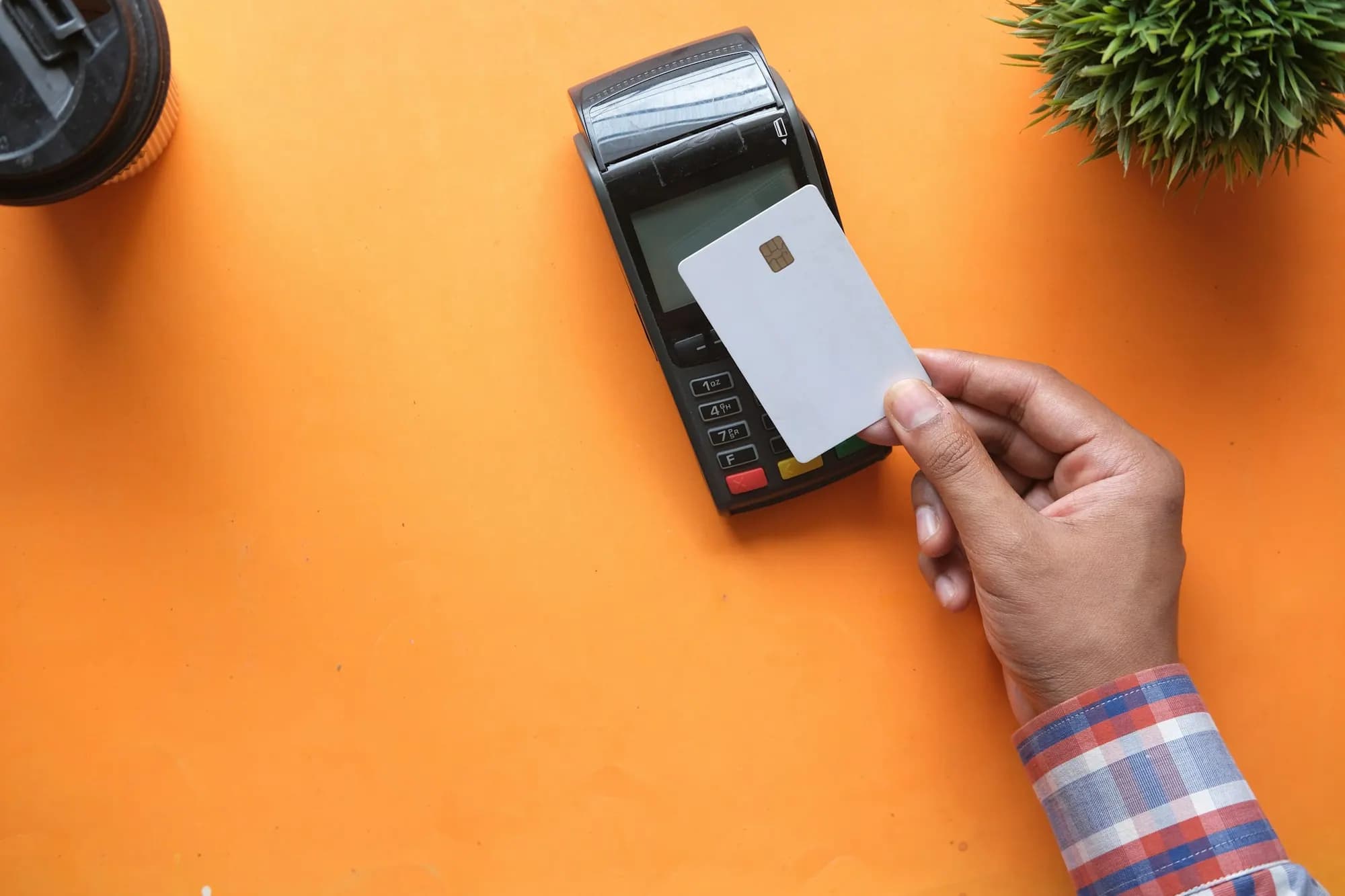 Hand tapping a card on a contactless payment terminal